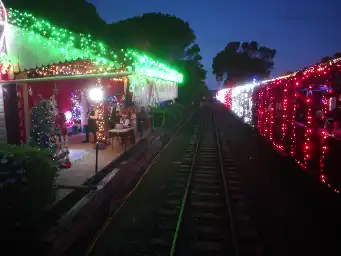 Train next to platform with Christmas lights